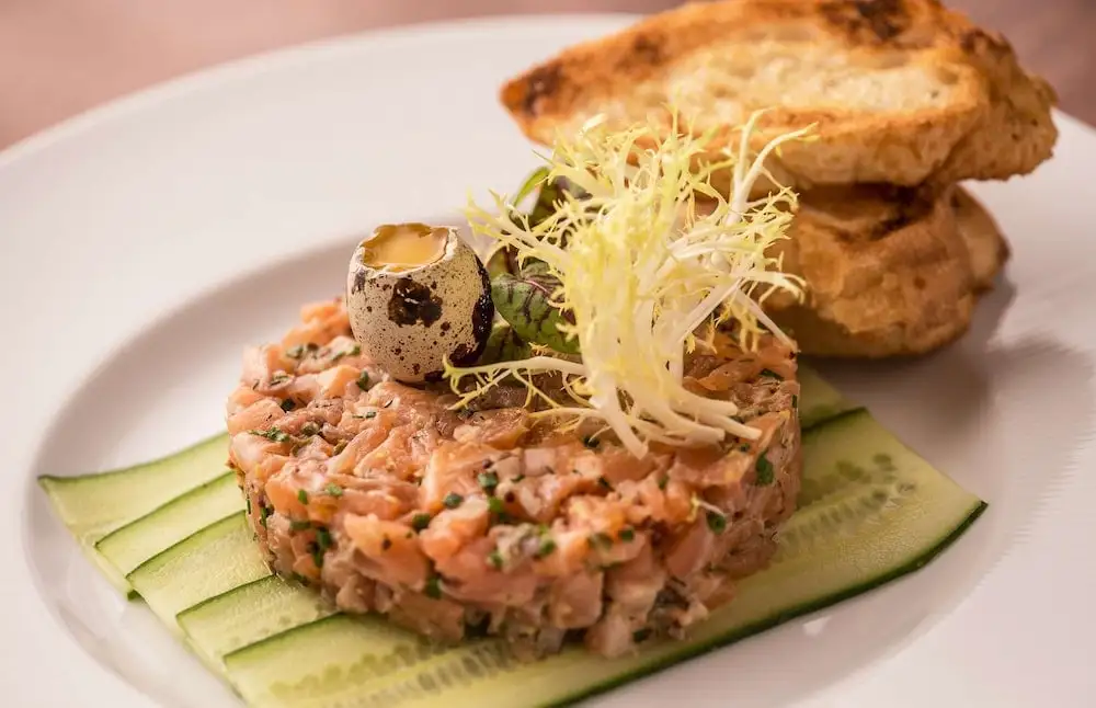 Salmon tartare with quail egg, microgreens, and toasted bread - an example dish from restaurants in the Loop and Millennium Park area